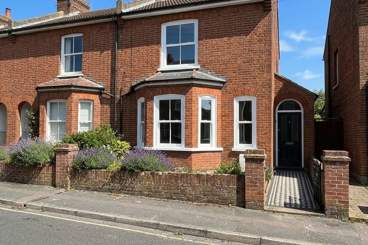 Victorian terrace with new white painted sash windows in a canted bay on a sunny day